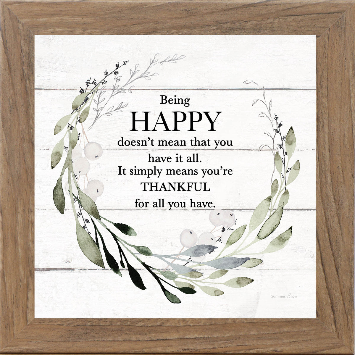 Framed inspirational wall art with the quote Being Happy doesn’t mean that you have it all, surrounded by green leafy florals on a white slatted wood background