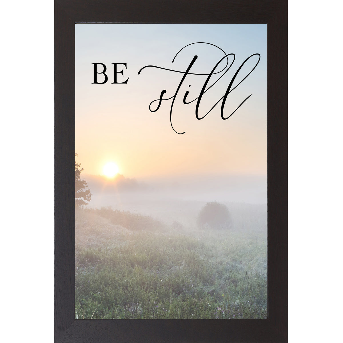 Black framed tall portrait Christian scripture wall art with misty sunrise field ground fog silhouetted trees and the words "Be Still" Psalm 46:10 — 27x40 inches