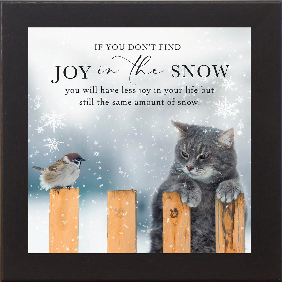 Winter wall art featuring a grumpy cat leaning on a snowy fence looking at a small bird perched nearby as snow falls, paired with a humorous quote about finding joy in the snow.