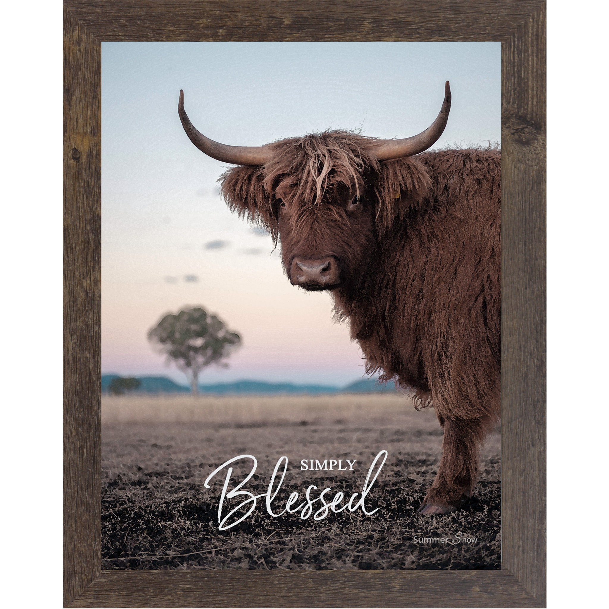 Natural Brown framed vertical farmhouse portrait wall art featuring a Highland cow with curved horns standing in a twilight field with a soft blush sky and lone tree with the words Simply Blessed