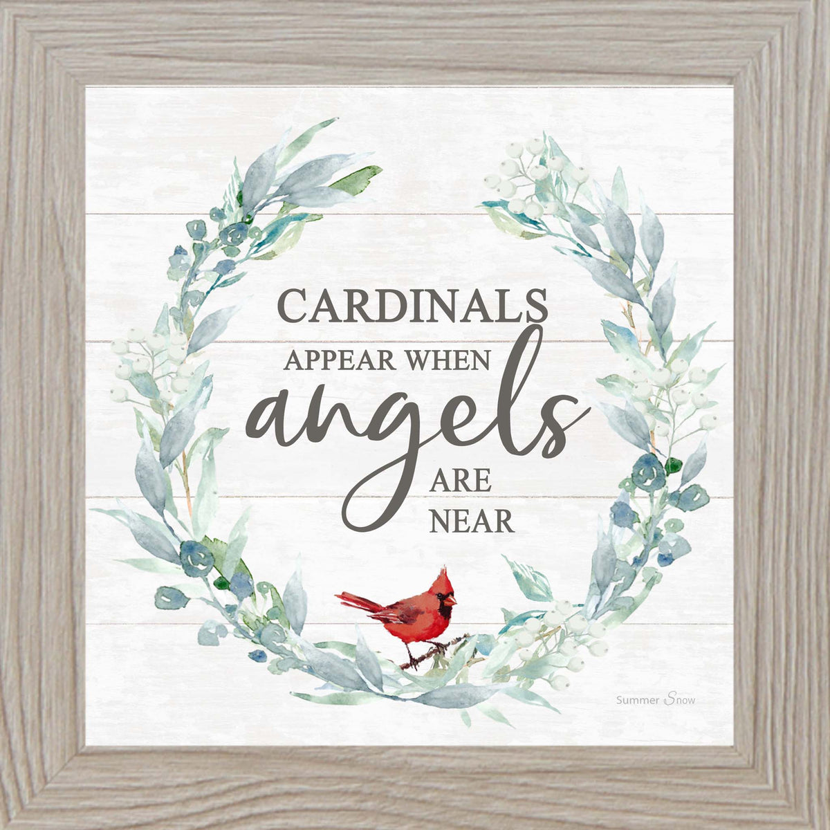 Square framed wall art featuring the phrase “Cardinals appear when angels are near” with a green floral wreath and red cardinal on a white slatted wood background