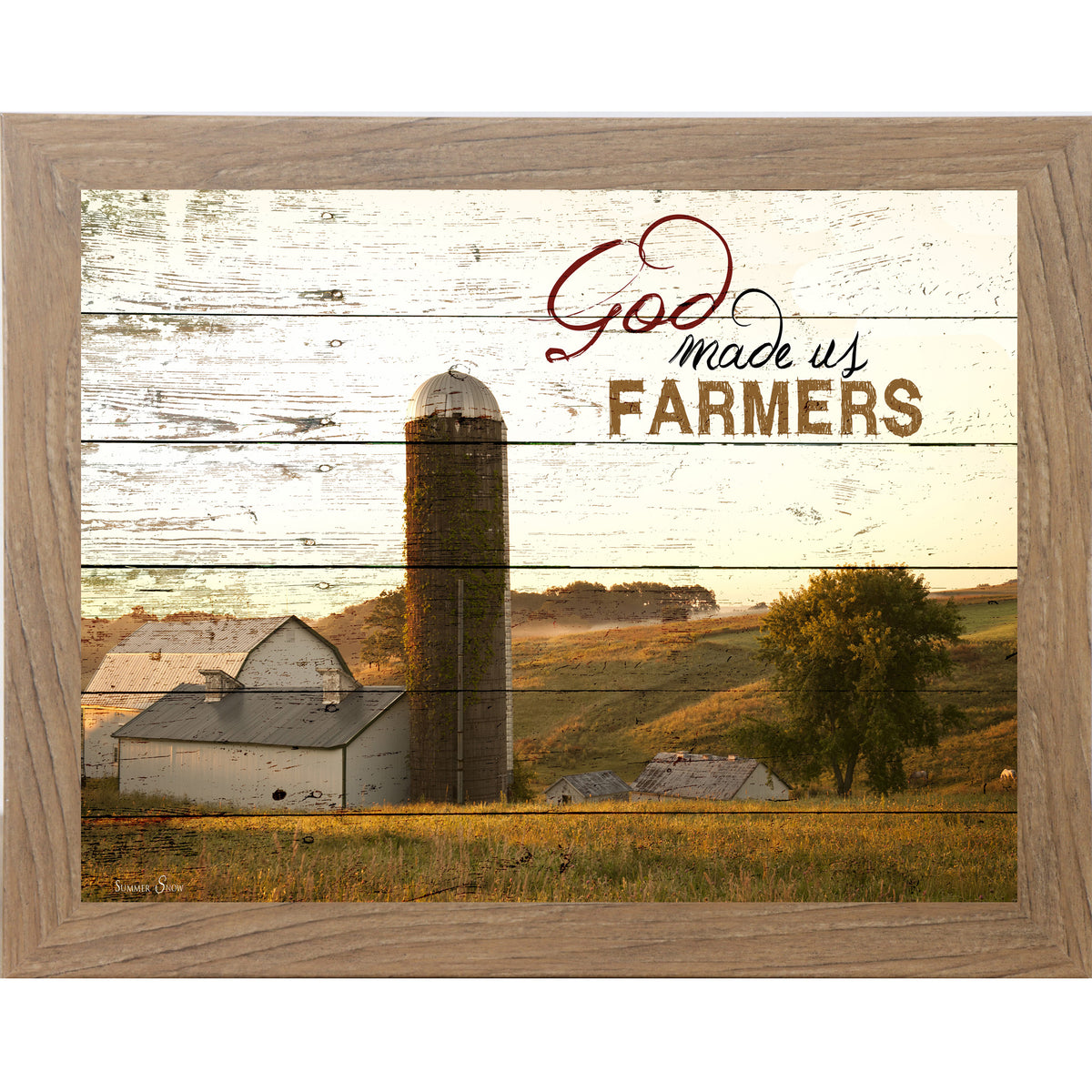 Farmtable framed horizontal farmhouse landscape wall art featuring a white barn and silo on rolling green hills with pallet wood background and the words God Made Us Farmers
