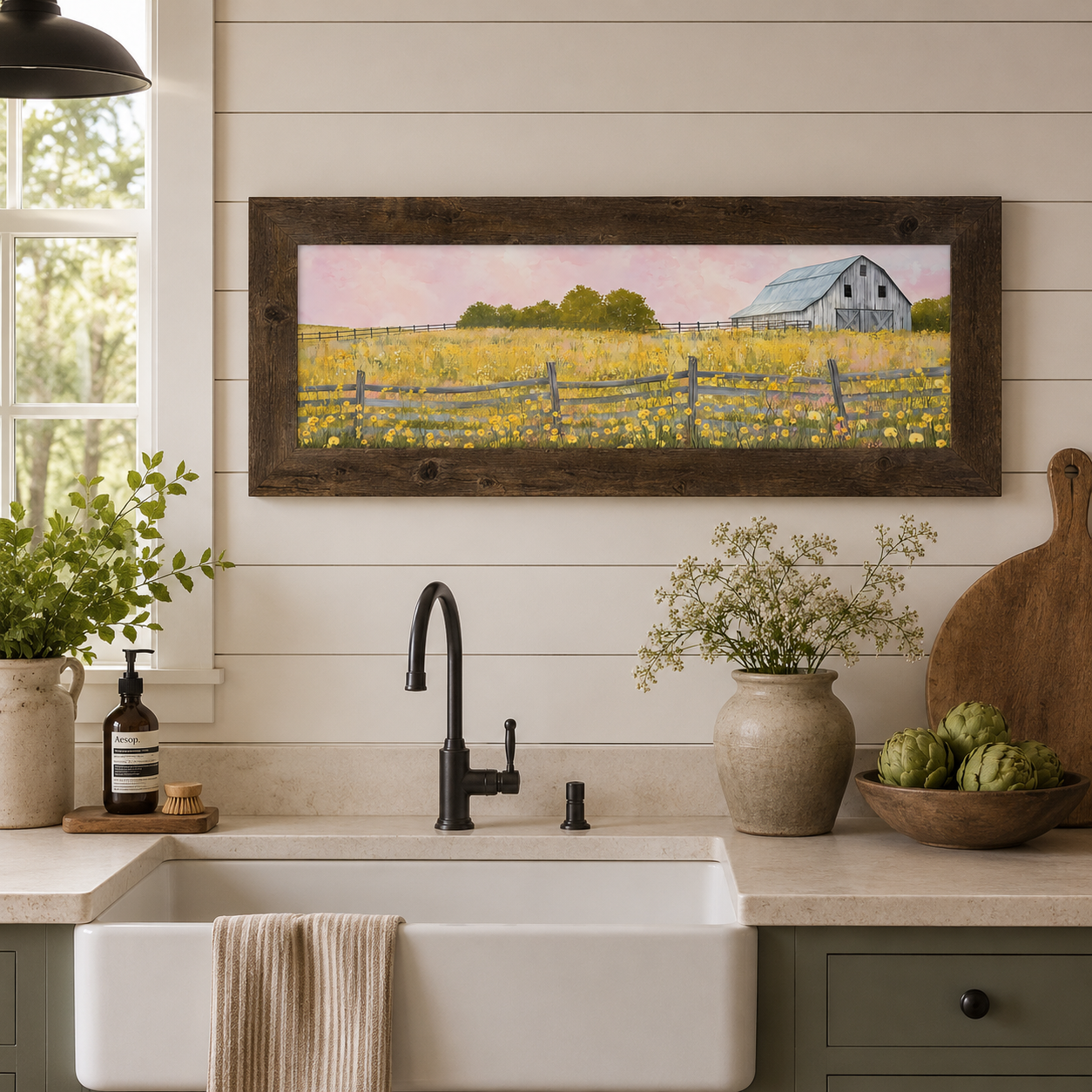 Farmhouse kitchen with Yellow Wildflower Barn wide landscape wall art SB950 in a natural brown 2.5 inch wide frame above a white farmhouse sink on shiplap wall — panoramic watercolor gray barn yellow wildflower meadow pink sky