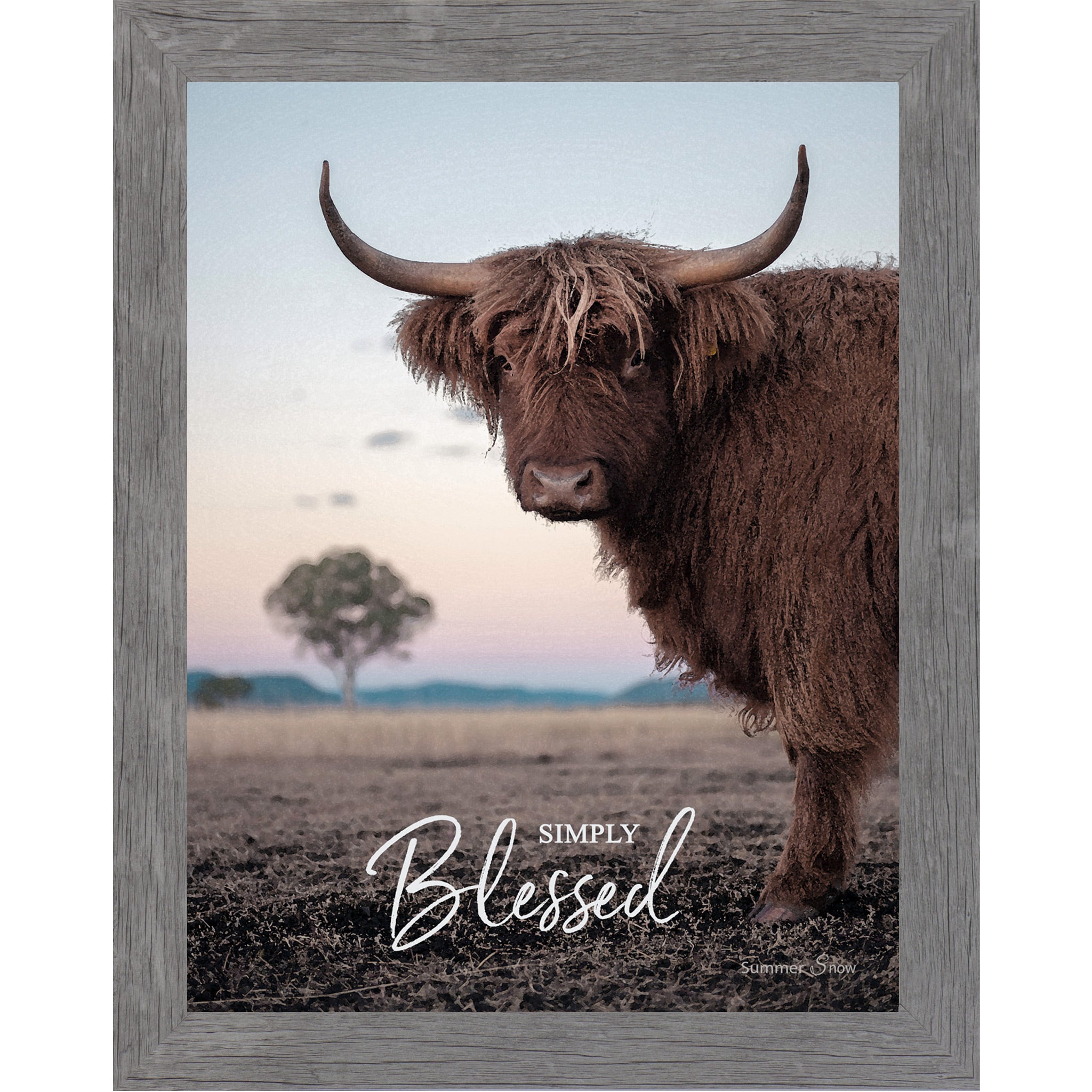 Gray framed vertical farmhouse portrait wall art featuring a Highland cow with curved horns standing in a twilight field with a soft blush sky and lone tree with the words Simply Blessed