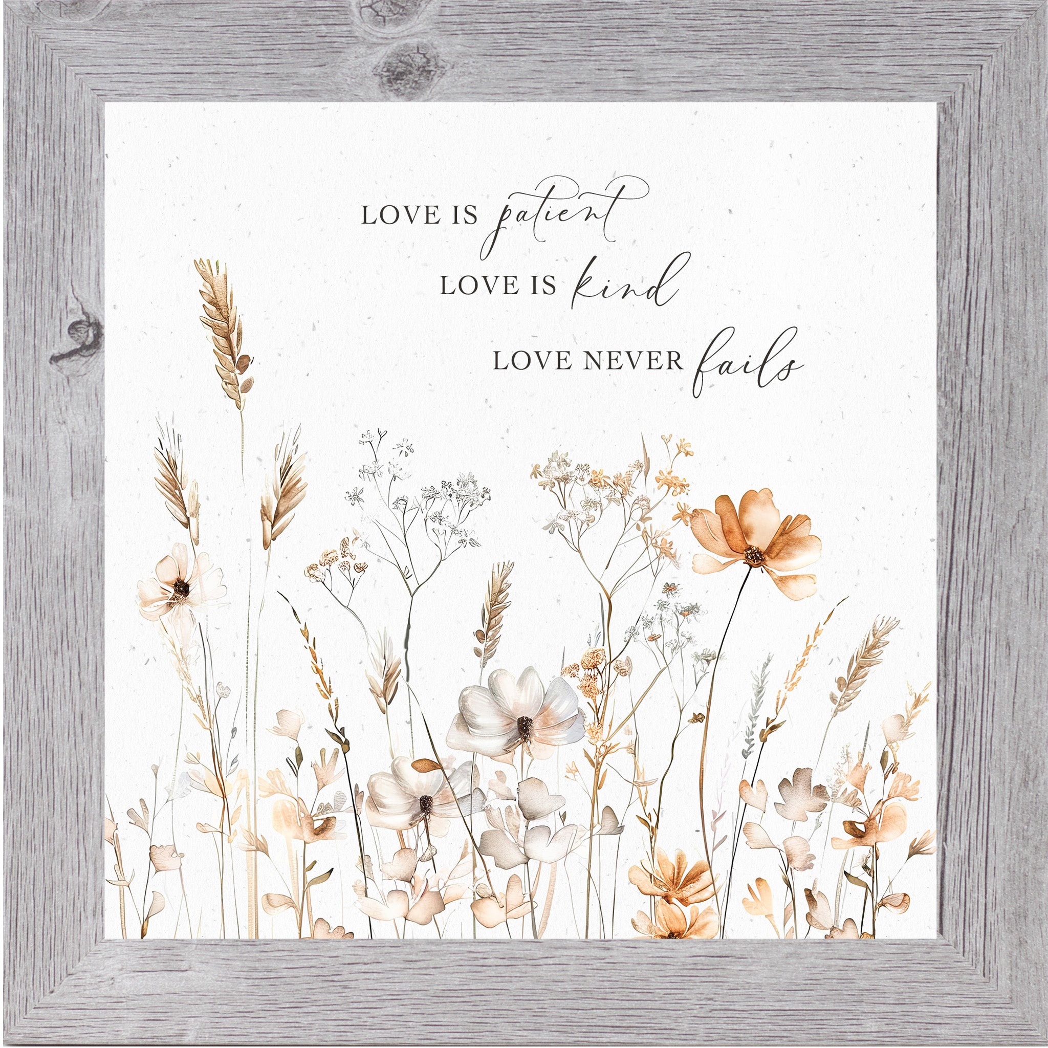 Gray framed square pastel floral wall art on white background with petite watercolor peach and white flowers and the quote "Love is Patient Love is Kind Love Never Fails"