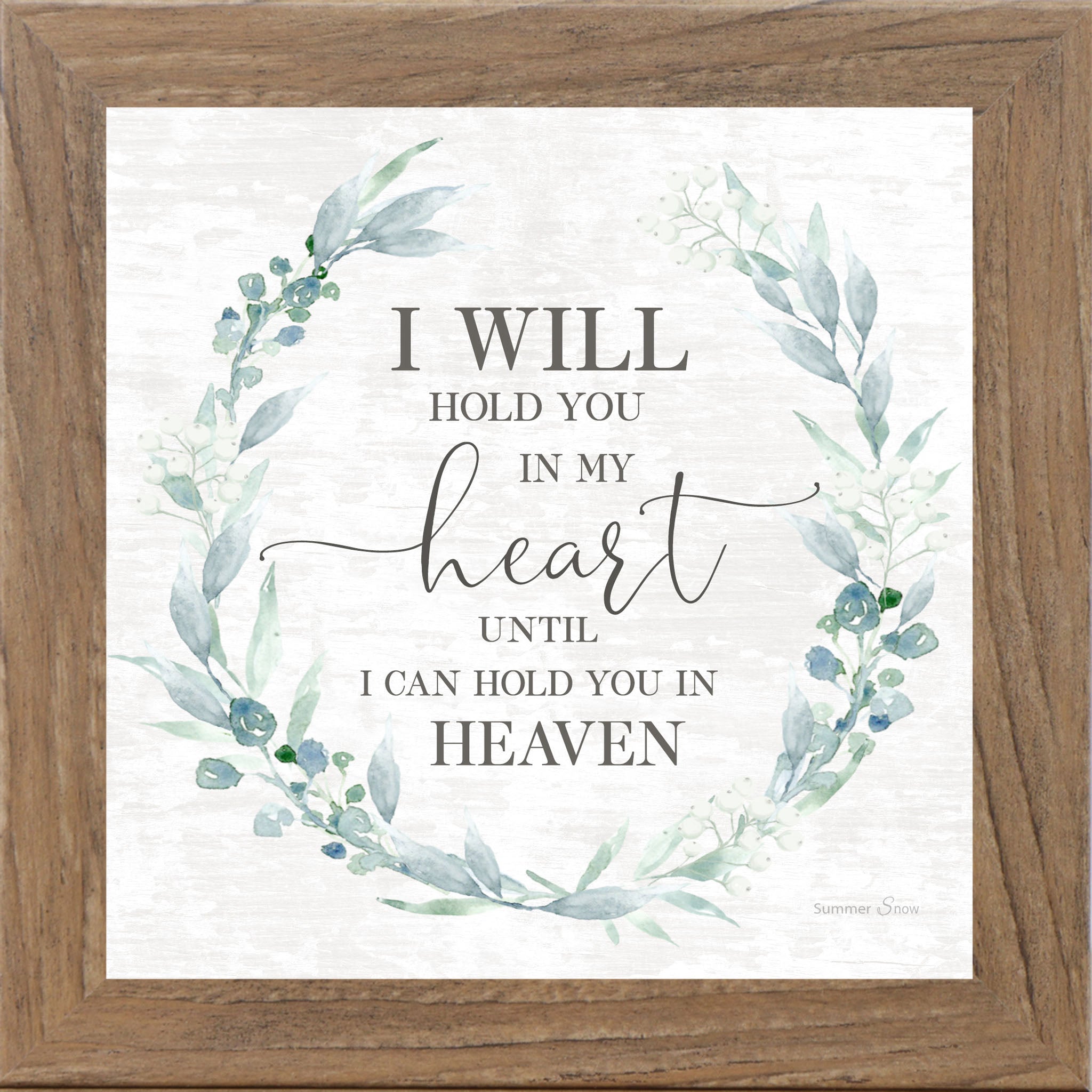 Framed sympathy wall art with the quote “I will hold you in my heart until I can hold you in heaven,” featuring a soft green floral wreath on a neutral white background.