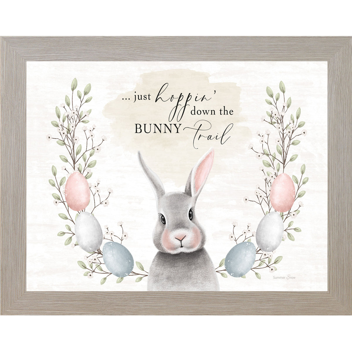 Horizontal framed wall art featuring cute gray bunny with egg and floral wreath and Just hoppin’ down the bunny trail quote on neutral background, Easter spring home decor