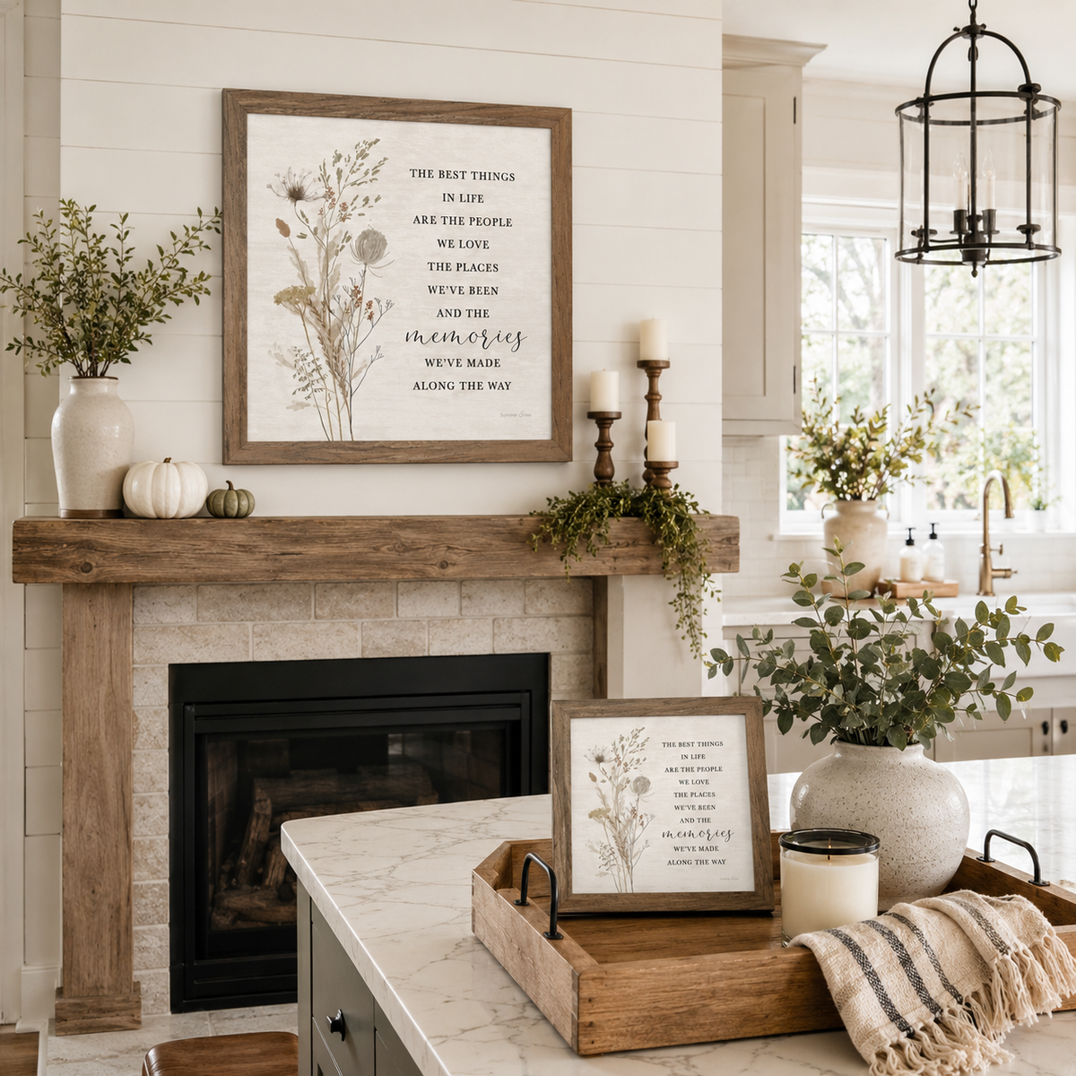 Farmtable framed 26x26 wildflower quote wall art displayed above a shiplap fireplace mantle with pumpkins, a stoneware vase of greenery, and candlesticks, alongside a matching 8x8 piece styled in a wooden tray on a marble kitchen island with a linen throw and candle
