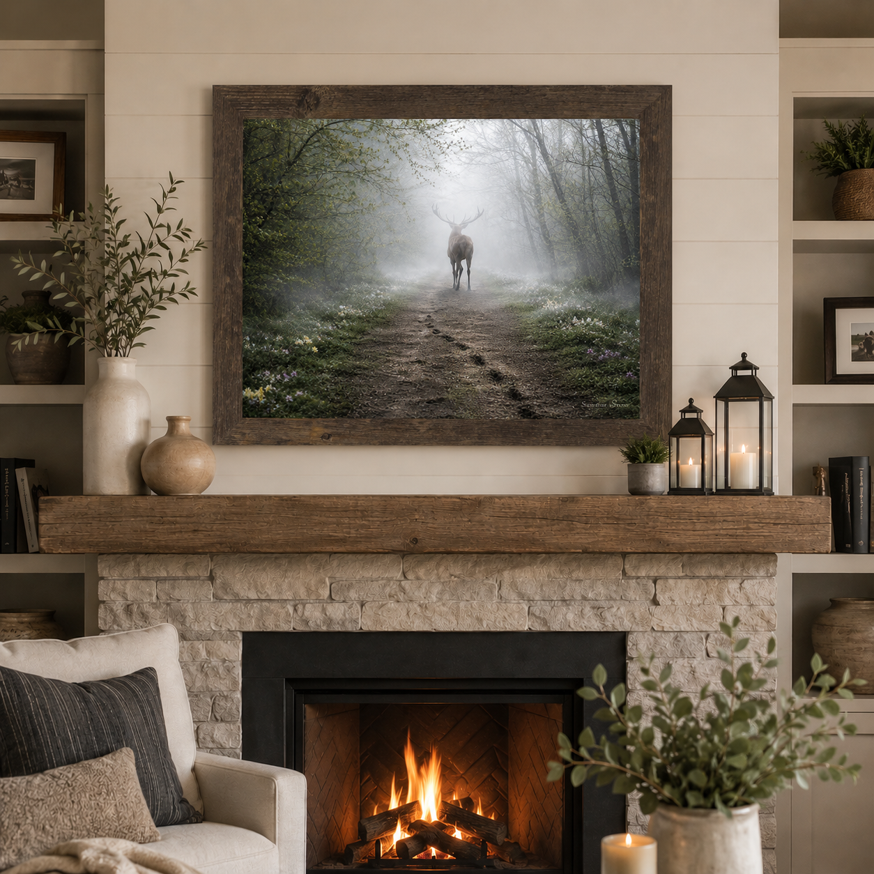 Natural brown framed horizontal ethereal misty deer forest path wall art featuring a deer silhouette dissolving into morning fog displayed as a large 32x26 statement piece above a stone fireplace mantle in a modern rustic living room with raw wood beam lanterns and shiplap walls