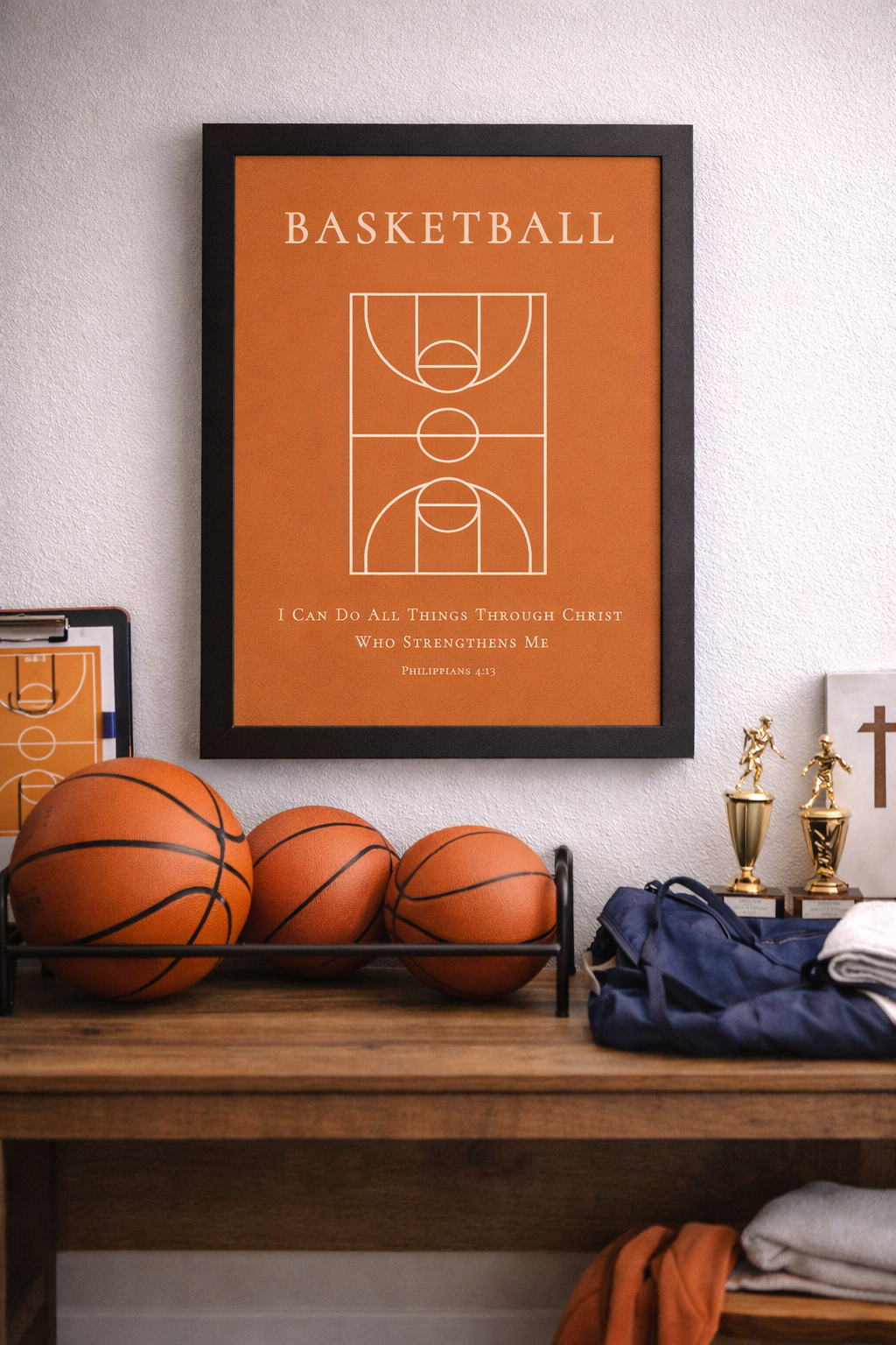 Room setting of a black framed Christian basketball wall art featuring a basketball court diagram with the Bible verse Philippians 4:13 on an orange background.