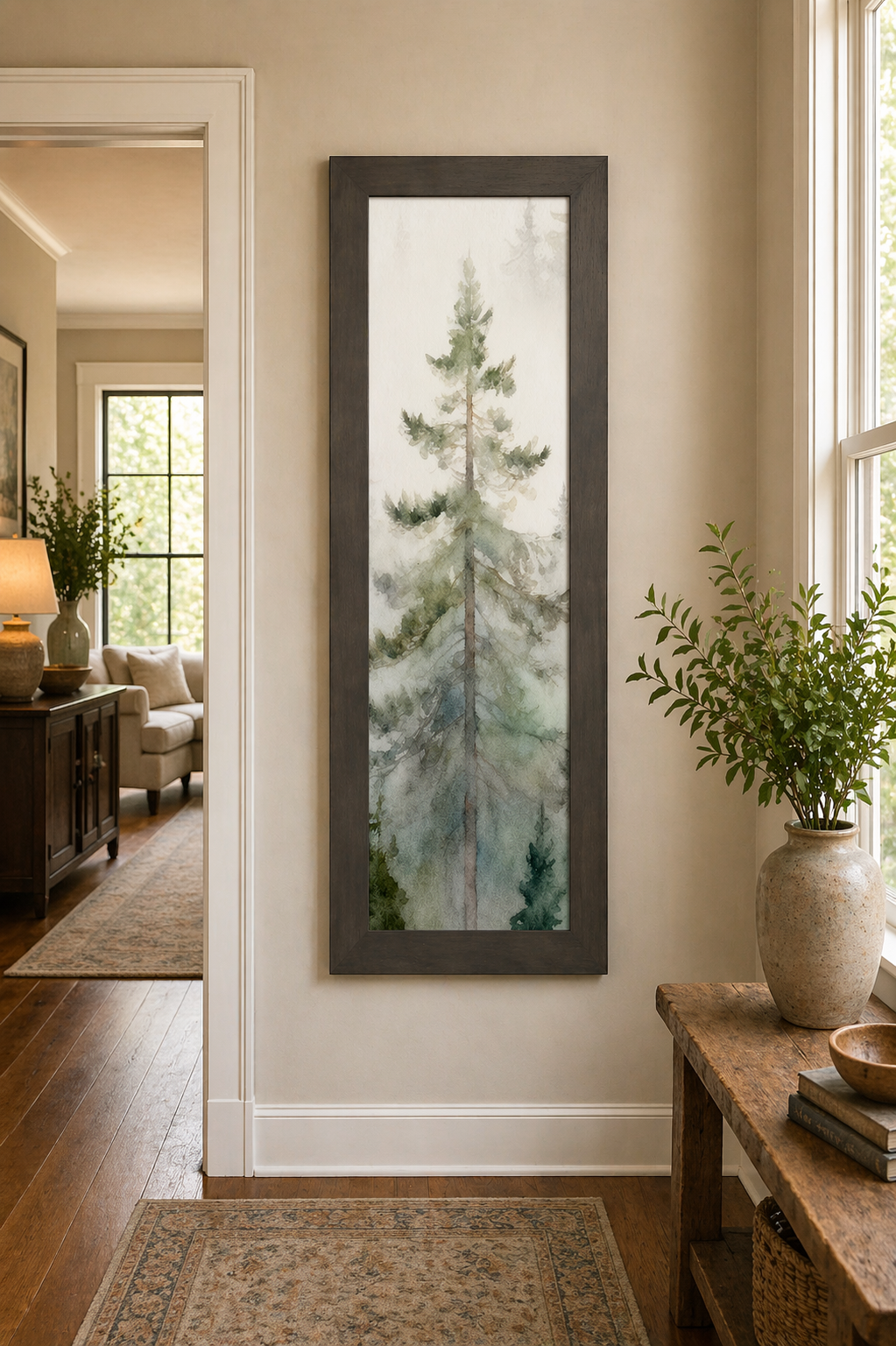 Slatewood framed narrow portrait watercolor pine forest wall art displayed at large scale in a warm neutral entryway hallway with hardwood floors showing single tall evergreen rising through soft morning mist with sage green misty forest background