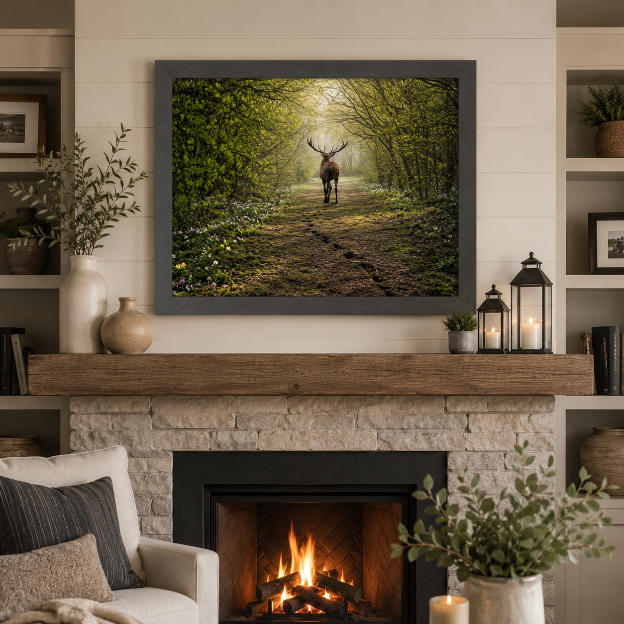 Slatewood framed horizontal spring deer forest path wall art featuring a deer walking into a misty green woodland displayed as a large 32x26 statement piece above a stone fireplace mantle in a modern rustic living room with raw wood beam lanterns and shiplap walls