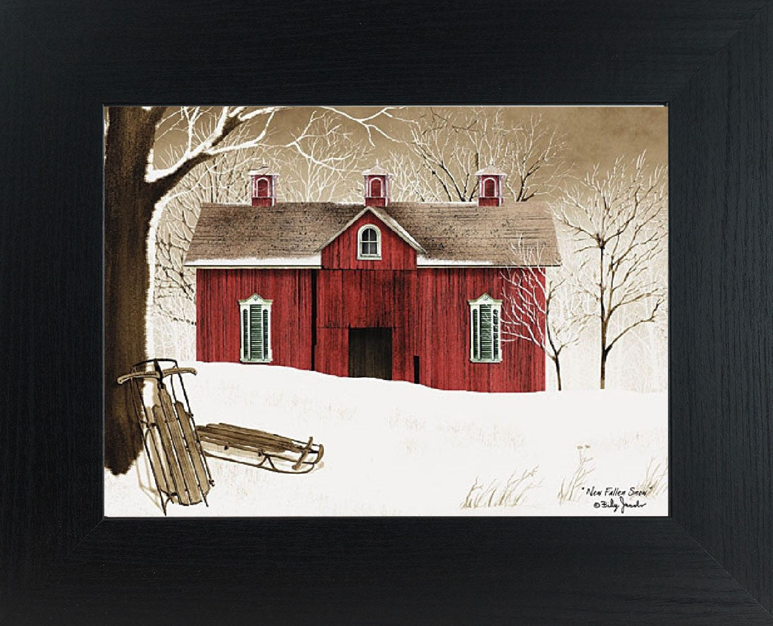 Framed winter barn wall art by Billy Jacobs showing a red barn in a snowy countryside with bare trees and two vintage wooden sleds resting in fresh fallen snow.